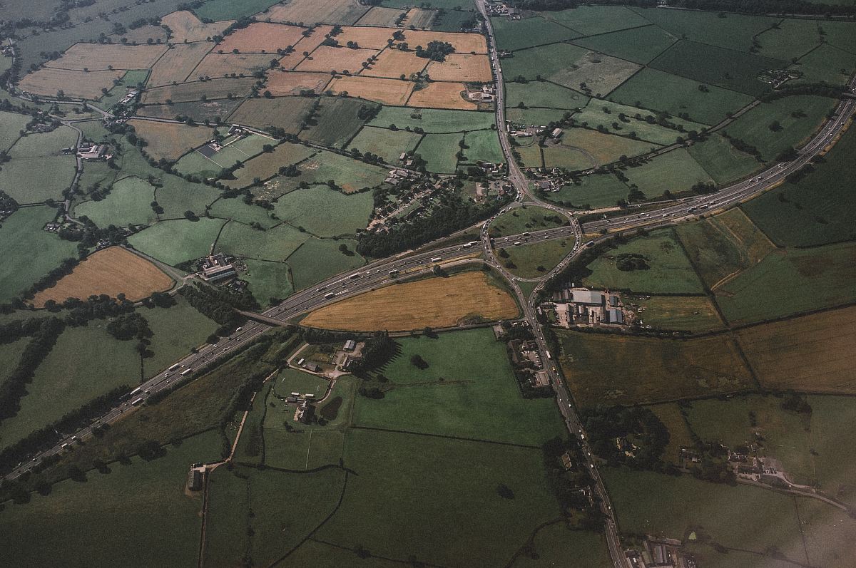 aerial photography of concrete roadway and green field
